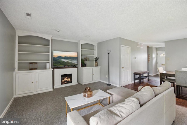 29 Twin Brooks Dr, Willow Grove, PA 19090 - living room with a textured ceiling, built in shelves, a warm lit fireplace, and carpet floors