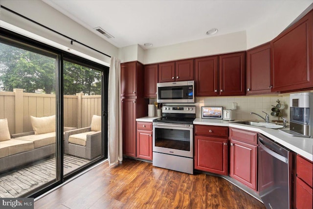 29 Twin Brooks Dr, Willow Grove, PA 19090 - kitchen with stainless steel appliances, reddish brown cabinets, light countertops, dark wood-style floors, and tasteful backsplash