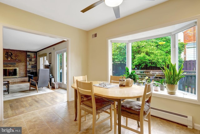 500 S Lexington St, Arlington, VA 22204 - dining room featuring a baseboard heating unit, a ceiling fan, a brick fireplace, and light tile patterned floors
