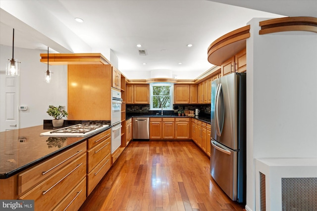 411 E Bellefonte Ave, Alexandria, VA 22301 - kitchen featuring appliances with stainless steel finishes, hardwood / wood-style floors, backsplash, recessed lighting, and dark stone counters