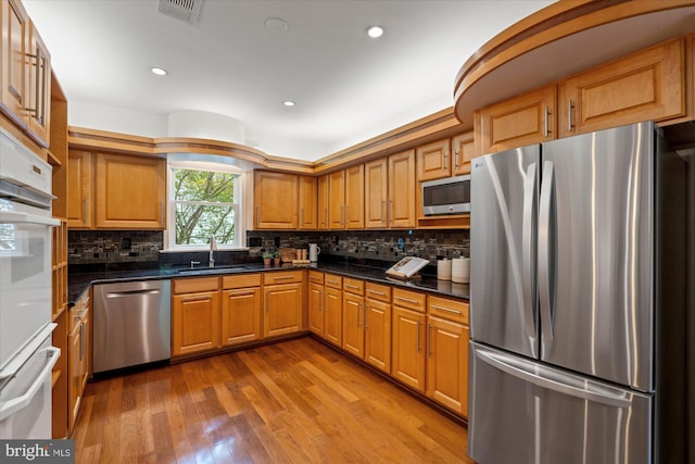411 E Bellefonte Ave, Alexandria, VA 22301 - kitchen featuring stainless steel appliances, wood finished floors, tasteful backsplash, brown cabinetry, and recessed lighting