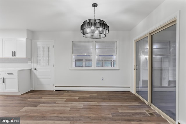 708 S Broad St, Mechanicsburg, PA 17055 - unfurnished dining area featuring baseboard heating, a chandelier, and wood finished floors