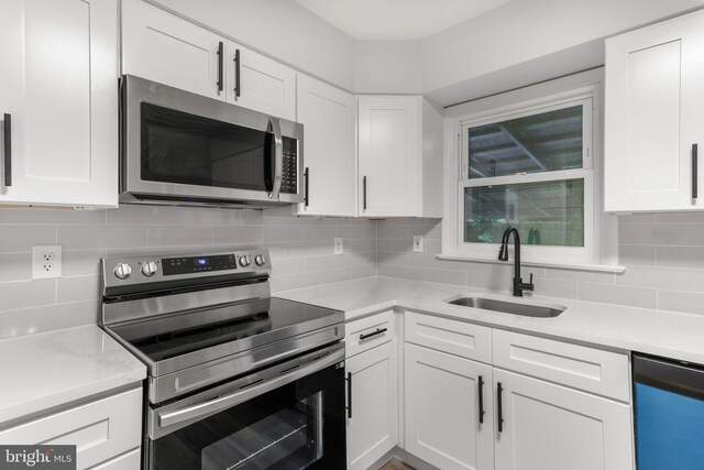 708 S Broad St, Mechanicsburg, PA 17055 - kitchen with stainless steel appliances, white cabinetry, and decorative backsplash