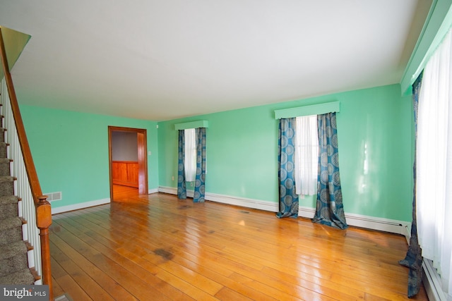 121 E James St, Winchester, VA 22601 - unfurnished room with baseboard heating, stairway, and wood-type flooring