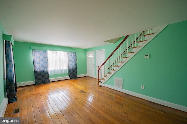 121 E James St, Winchester, VA 22601 - unfurnished living room with stairway, baseboard heating, and wood-type flooring