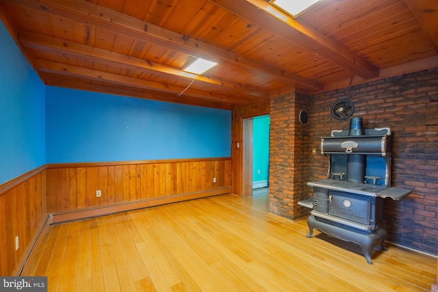 121 E James St, Winchester, VA 22601 - unfurnished living room featuring a wood stove, a wood ceiling with exposed beams, a baseboard heating unit, hardwood / wood-style floors, and wainscoting