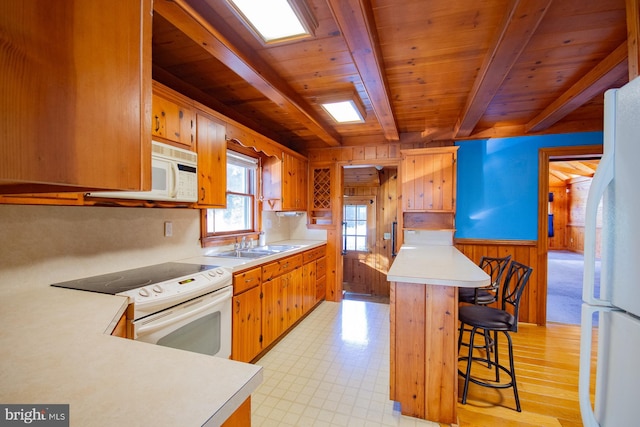 121 E James St, Winchester, VA 22601 - kitchen featuring white appliances, a wood ceiling with exposed beams, light countertops, wooden walls, and light flooring