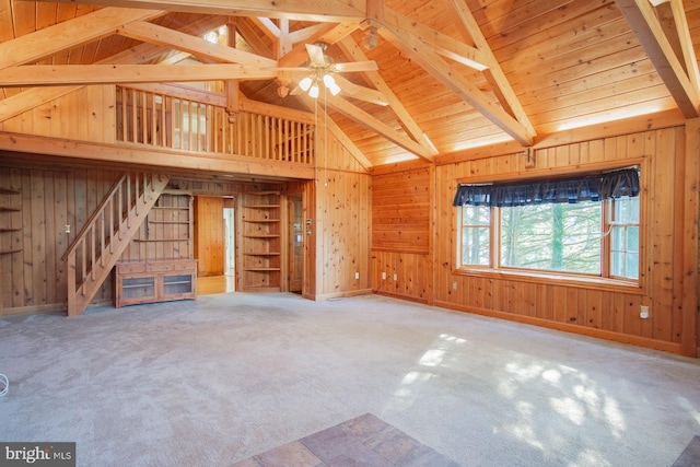 121 E James St, Winchester, VA 22601 - unfurnished living room with wooden walls, stairs, a ceiling fan, a wooden ceiling with exposed beams, and carpet