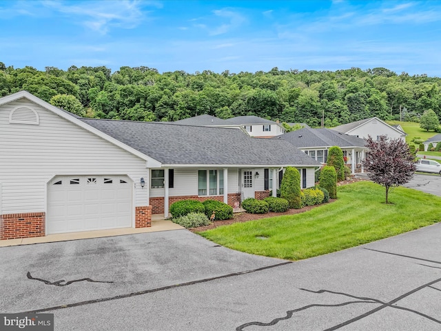 23 Garden Dr, Berkeley Springs, WV 25411 - traditional-style home with brick siding, covered porch, an attached garage, a front yard, and asphalt driveway