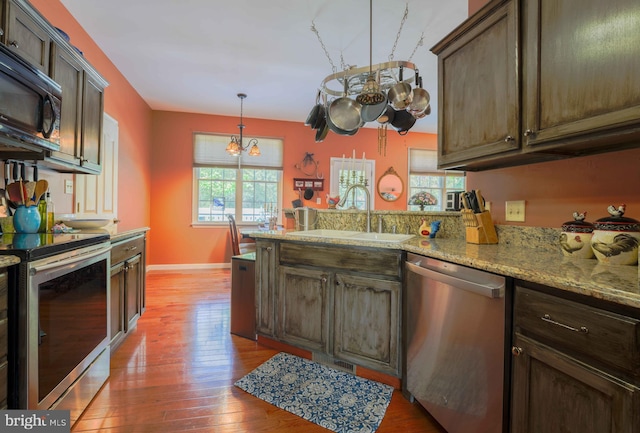 34 N Erin Ave, Felton, DE 19943 - kitchen with appliances with stainless steel finishes, a chandelier, a peninsula, light wood-style flooring, and light stone counters