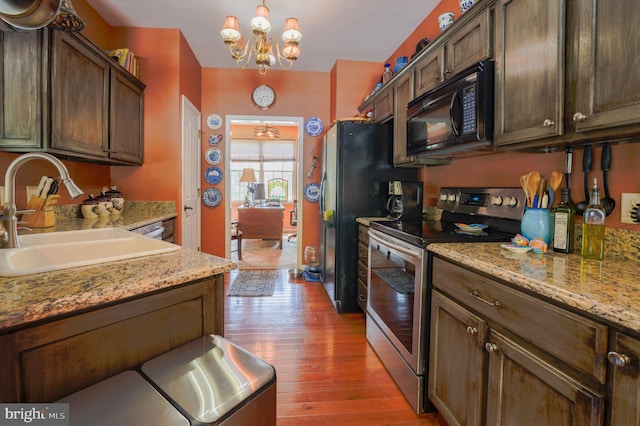 34 N Erin Ave, Felton, DE 19943 - kitchen featuring black appliances, wood-type flooring, a chandelier, hanging light fixtures, and light stone counters