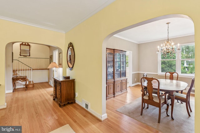 3917 Fessenden St NW, Washington, DC 20016 - dining space with arched walkways, light wood-style floors, ornamental molding, and a chandelier