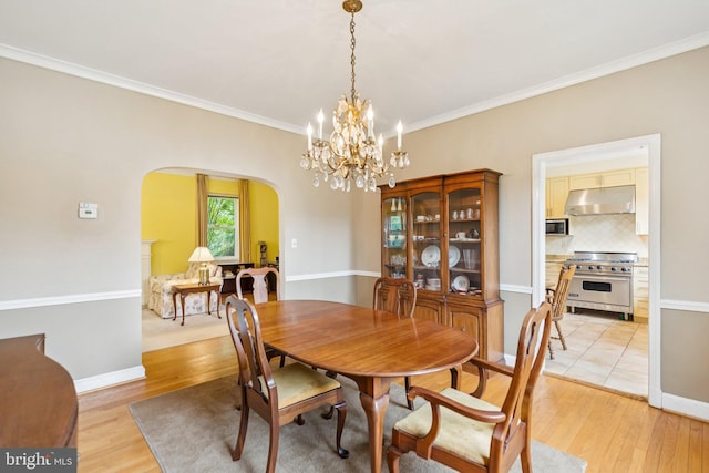 3917 Fessenden St NW, Washington, DC 20016 - dining area with arched walkways, light wood finished floors, crown molding, and a chandelier