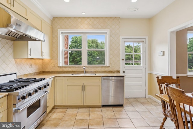 3917 Fessenden St NW, Washington, DC 20016 - kitchen with stainless steel appliances, under cabinet range hood, cream cabinetry, light countertops, and backsplash