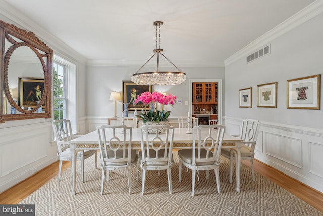 10 Callery Way, Malvern, PA 19355 - dining area with a chandelier, light wood-type flooring, a decorative wall, a wainscoted wall, and crown molding