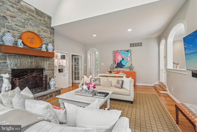 10 Callery Way, Malvern, PA 19355 - living area with wood finished floors, arched walkways, a stone fireplace, and recessed lighting