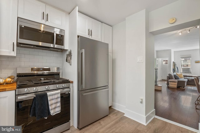 2229 S Darien St, Philadelphia, PA 19148 - kitchen with appliances with stainless steel finishes, white cabinetry, backsplash, light wood-style flooring, and wood counters