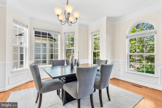 4509 Rhett Ln, Fairfax, VA 22030 - dining space with a chandelier, healthy amount of natural light, wood finished floors, a wainscoted wall, and ornamental molding