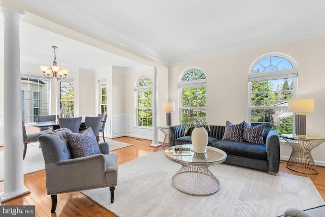 4509 Rhett Ln, Fairfax, VA 22030 - living room featuring ornate columns, a chandelier, wood finished floors, ornamental molding, and wainscoting
