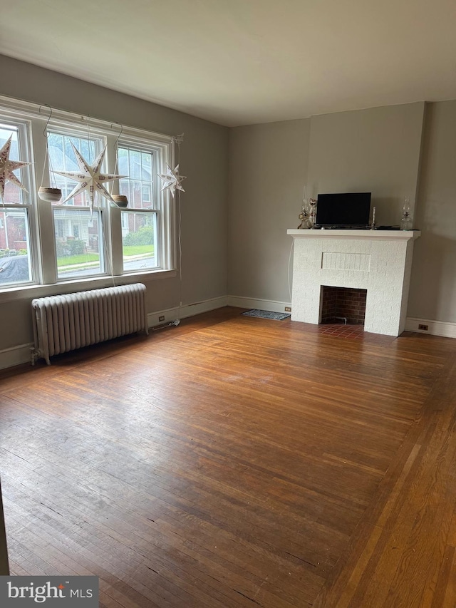 516 N 25th St, Reading, PA 19606 - unfurnished living room featuring radiator, wood finished floors, and a fireplace