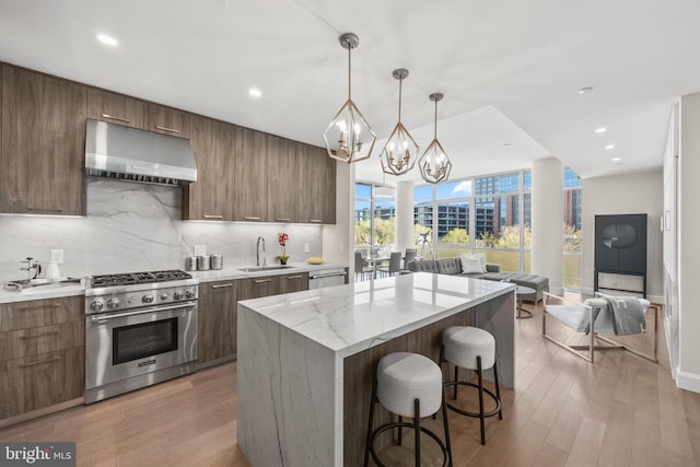 1330 Lancaster St Unit C601, Baltimore, MD 21231 - kitchen featuring appliances with stainless steel finishes, under cabinet range hood, modern cabinets, a chandelier, and a kitchen breakfast bar