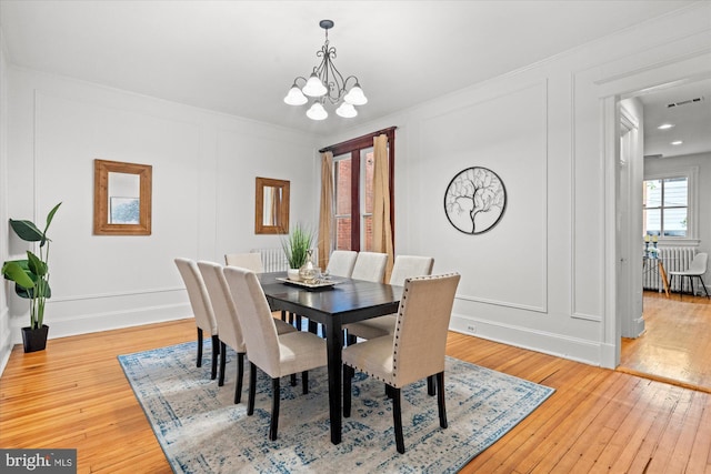 2637 Garfield St NW, Washington, DC 20008 - dining room with a decorative wall, a chandelier, light wood finished floors, and crown molding