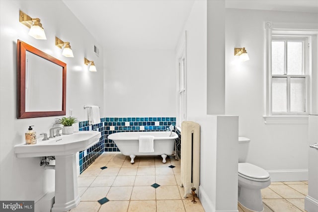 2637 Garfield St NW, Washington, DC 20008 - full bath with radiator heating unit, tile patterned floors, a freestanding tub, wainscoting, and tile walls