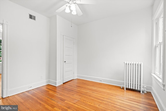 2637 Garfield St NW, Washington, DC 20008 - unfurnished bedroom featuring radiator heating unit, light wood-style floors, and a ceiling fan