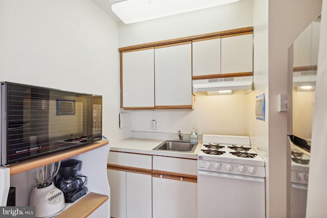 2101 Chestnut St Unit 909, Philadelphia, PA 19103 - kitchen featuring white range with gas cooktop, under cabinet range hood, white cabinetry, light countertops, and fridge