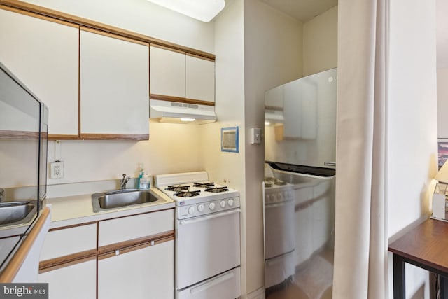 2101 Chestnut St Unit 909, Philadelphia, PA 19103 - kitchen with white range with gas cooktop, under cabinet range hood, refrigerator, white cabinetry, and light countertops