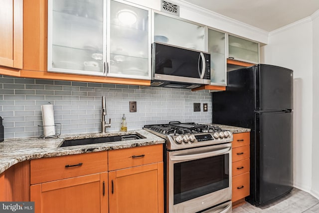 423 5th St SE, Washington, DC 20003 - kitchen with appliances with stainless steel finishes, ornamental molding, light stone countertops, backsplash, and glass insert cabinets