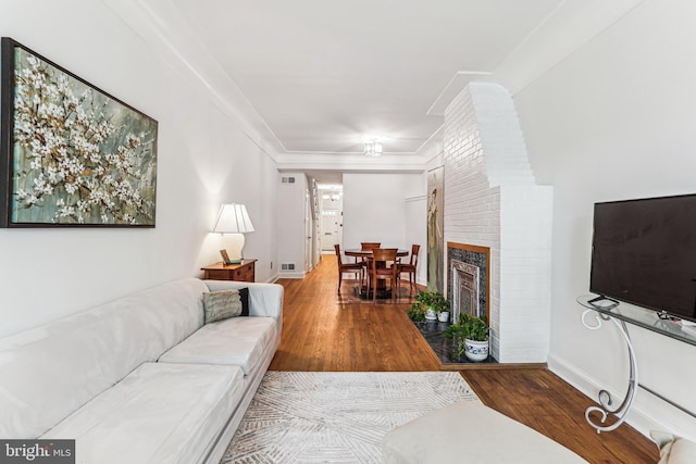 423 5th St SE, Washington, DC 20003 - living room with wood finished floors, ornamental molding, and a brick fireplace
