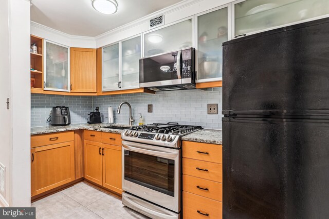 423 5th St SE, Washington, DC 20003 - kitchen with stainless steel appliances, tasteful backsplash, light stone countertops, light tile patterned floors, and open shelves