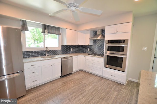 207 Maryland Ave, Newport, DE 19804 - kitchen featuring stainless steel appliances, wall chimney range hood, white cabinets, and decorative backsplash