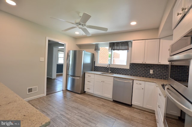 207 Maryland Ave, Newport, DE 19804 - kitchen featuring stainless steel appliances, decorative backsplash, white cabinets, ceiling fan, and recessed lighting