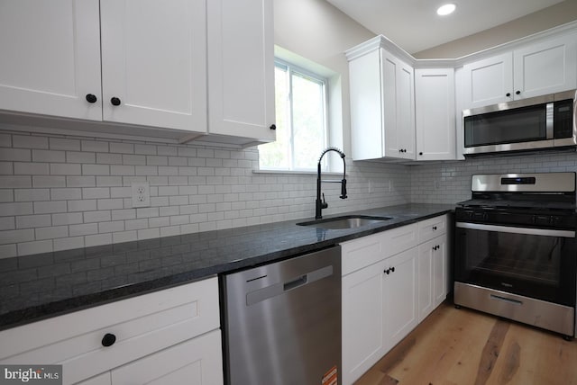 2 Schooner Landing Rd, Millville, NJ 08332 - kitchen with appliances with stainless steel finishes, white cabinets, dark stone counters, light wood-type flooring, and backsplash