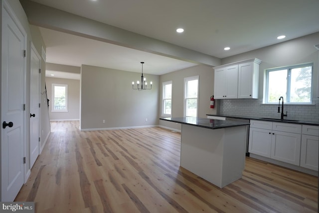 2 Schooner Landing Rd, Millville, NJ 08332 - kitchen with dark countertops, light wood-type flooring, a chandelier, decorative backsplash, and white cabinets