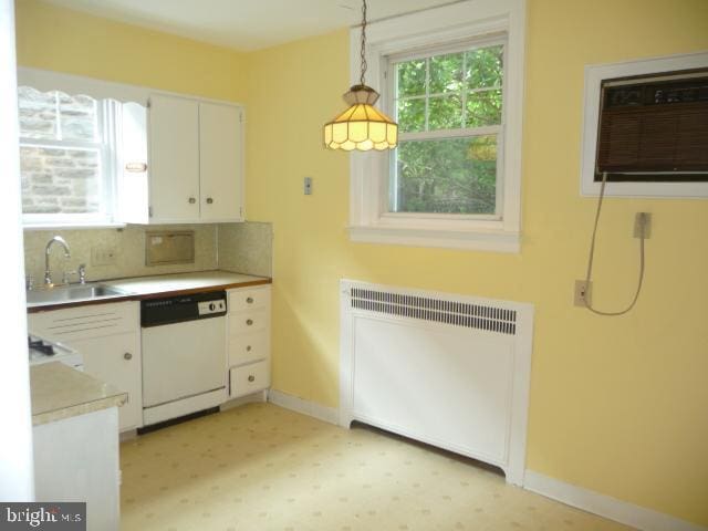 537 E Comly St, Philadelphia, PA 19120 - kitchen with radiator heating unit, dishwasher, white cabinetry, tasteful backsplash, and light countertops