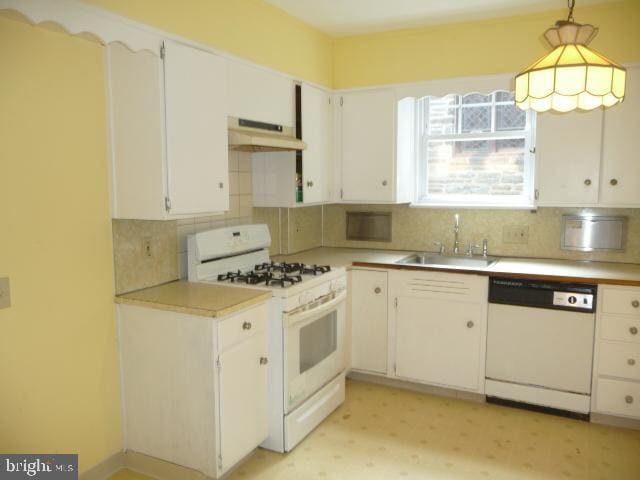 537 E Comly St, Philadelphia, PA 19120 - kitchen with white appliances, under cabinet range hood, decorative backsplash, light countertops, and white cabinetry