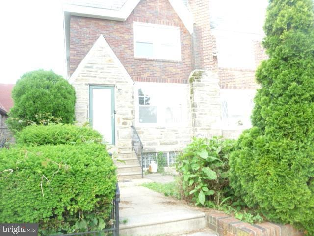 537 E Comly St, Philadelphia, PA 19120 - view of front of property featuring brick siding, entry steps, and stone siding