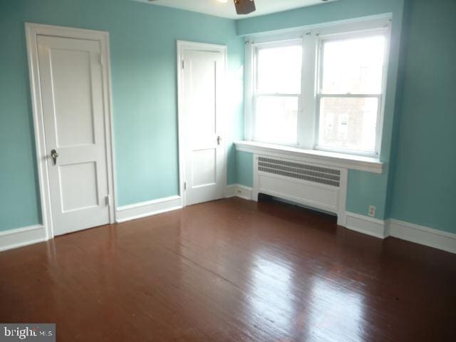 537 E Comly St, Philadelphia, PA 19120 - unfurnished bedroom featuring radiator, wood finished floors, and ceiling fan