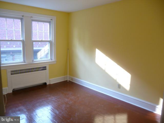 537 E Comly St, Philadelphia, PA 19120 - spare room featuring radiator and wood finished floors