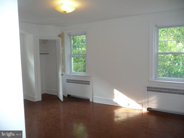 537 E Comly St, Philadelphia, PA 19120 - unfurnished bedroom featuring radiator heating unit and multiple windows