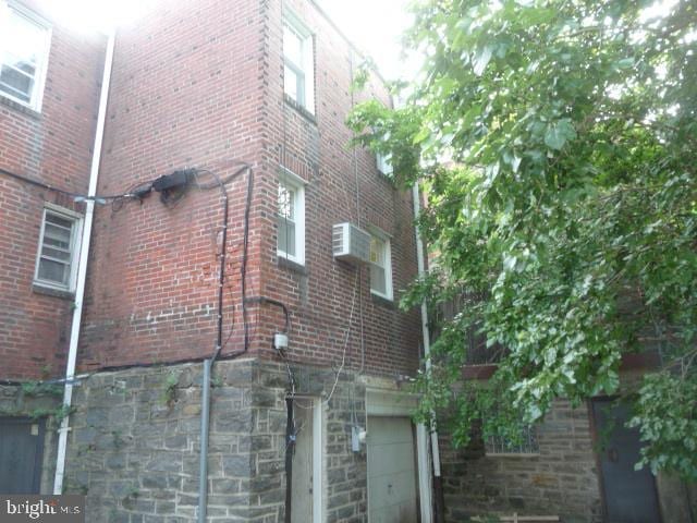 537 E Comly St, Philadelphia, PA 19120 - view of side of home featuring stone siding, brick siding, and an attached garage