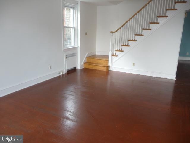 537 E Comly St, Philadelphia, PA 19120 - unfurnished living room with wood finished floors, radiator, and stairs