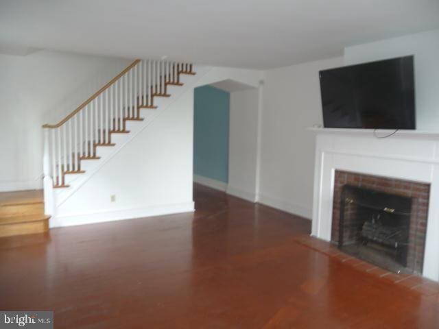 537 E Comly St, Philadelphia, PA 19120 - unfurnished living room featuring a fireplace, stairway, and wood finished floors