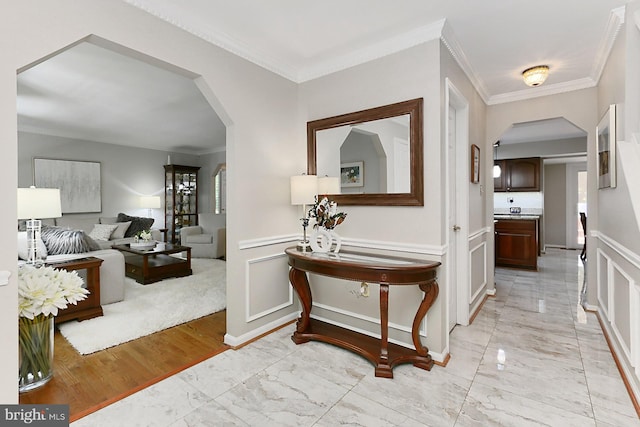 11166 Deuaughn Ct, Fairfax Station, VA 22039 - hall featuring arched walkways, light marble finish floors, ornamental molding, a wainscoted wall, and a decorative wall