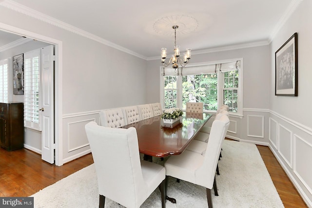 11166 Deuaughn Ct, Fairfax Station, VA 22039 - dining area with a chandelier, dark wood-style floors, ornamental molding, a wainscoted wall, and a decorative wall