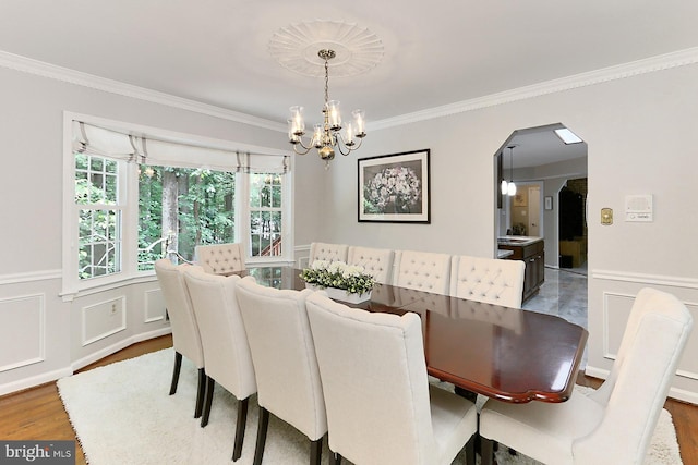 11166 Deuaughn Ct, Fairfax Station, VA 22039 - dining room with a chandelier, wood finished floors, ornamental molding, arched walkways, and wainscoting
