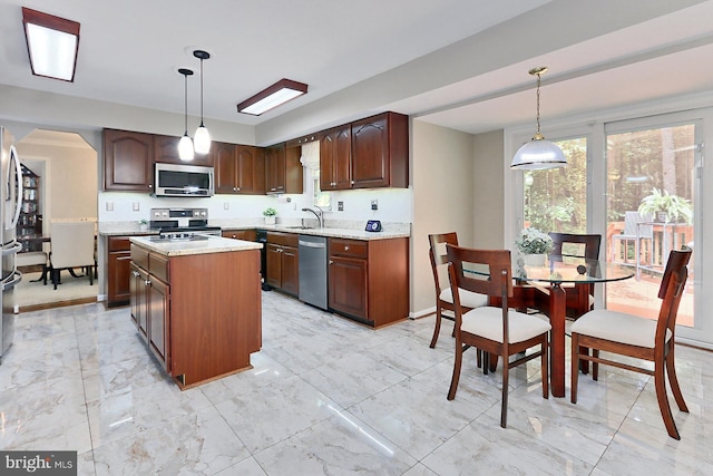 11166 Deuaughn Ct, Fairfax Station, VA 22039 - kitchen featuring stainless steel appliances, light marble finish flooring, a kitchen island, and decorative light fixtures